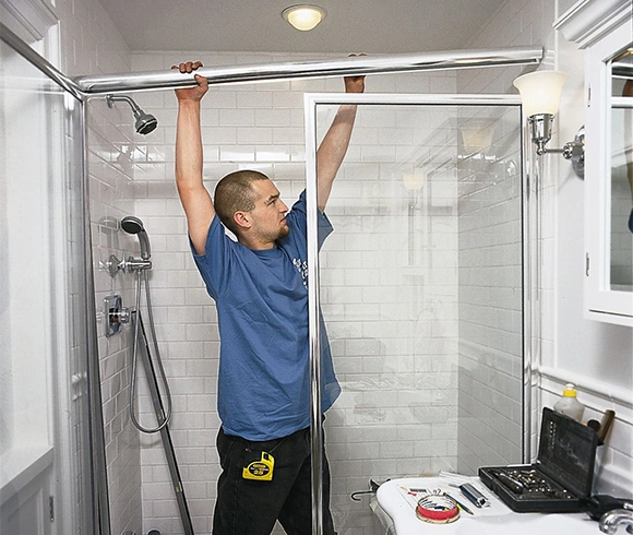 Professional installer adjusting shower curtain rod in modern bathroom.