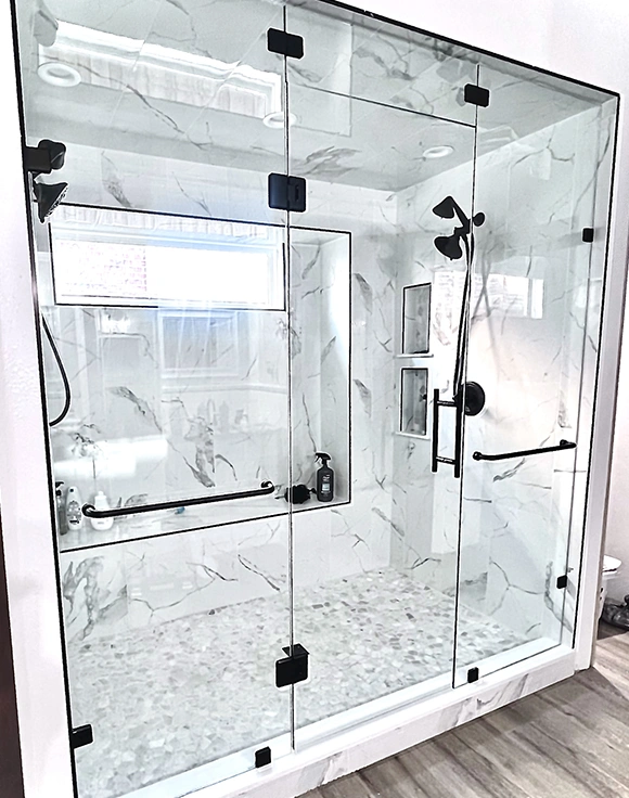 Modern glass shower door with marble walls.